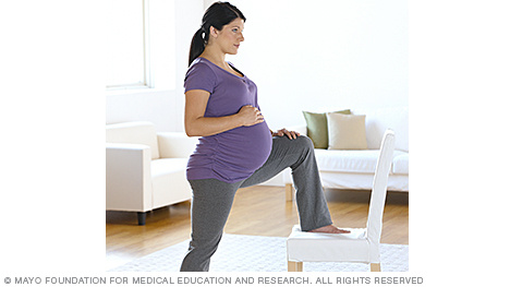 A person in labor lunging against a chair